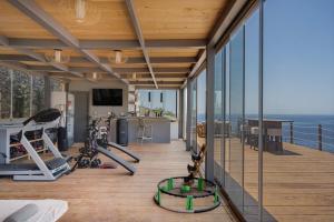 an indoor gym with a view of the ocean at Blueros - Grey Suite in Megas Gialos - Nites
