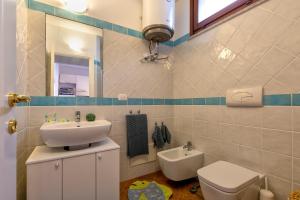 a bathroom with a sink and a toilet and a mirror at Gio's Apartment in Castelsardo +18 photos