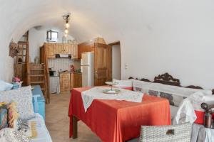 a living room with a table and a kitchen at Palatino in Astypalaia