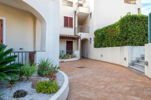 a courtyard of a white building with plants at Gio's Apartment in Castelsardo