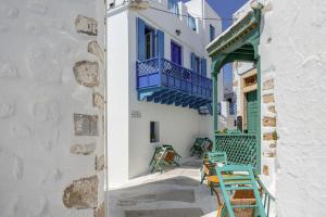 a street with chairs and a building with a balcony at Palatino in Astypalaia