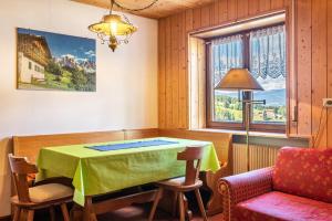 a dining room with a table and a couch at Pension Sonia App 103 in Funes