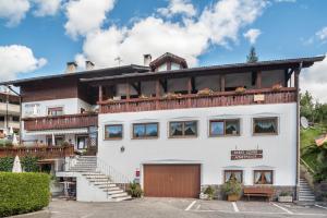 a white house with a balcony on top of it at Pension Sonia App 103 in Funes