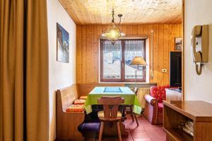 a dining room with a table with a green table cloth at Pension Sonia App 103 in Funes +19 photos