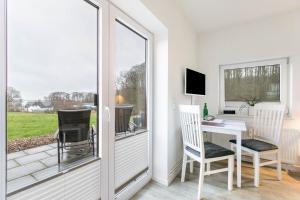 a room with a desk and chairs and a window at Ferienhaus Ostseeblick in Munkbrarup