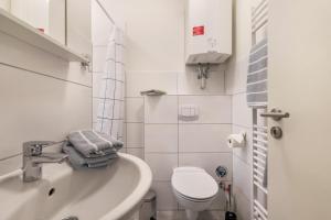 a white bathroom with a toilet and a sink at Ferienhaus Ostseeblick in Munkbrarup +16 photos