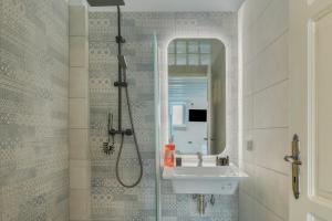 a bathroom with a shower and a sink and a mirror at Palatino in Astypalaia