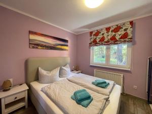 a bedroom with a bed with two towels on it at Ferienhaus Specht in Zossen