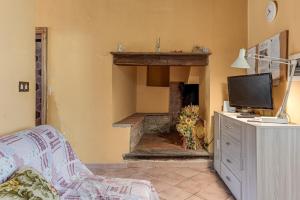 a living room with a fireplace and a tv at Agriturismo Il Ponte - Frantoio in Vicchio