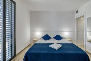 a bedroom with a bed with blue sheets and blue pillows at Rostella Apartment in Roses +17 photos