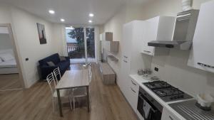 a kitchen and living room with a table and a couch at Casa Nicla in Colico +2 photos