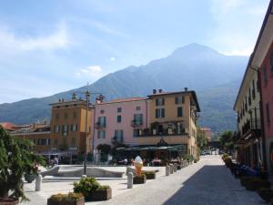a city street with buildings and mountains in the background at Casa Nicla in Colico