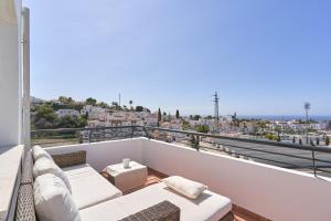 a balcony with a couch and a view of a city at Paraíso Azul in Nerja