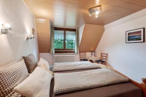 two beds in a small room with a window at Ferienwohnung Schweizer in Bernau im Schwarzwald