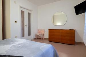 a bedroom with a bed and a dresser and a mirror at Bellavita and pool in Brindisi