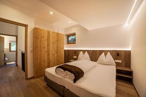 a bedroom with a large white bed in a room at Flatschhof - Chalet Flatsch in Kastelbell-Tschars