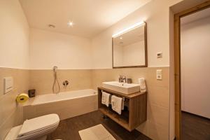 a bathroom with a sink and a tub and a toilet at Flatschhof - Chalet Flatsch in Kastelbell-Tschars +17 photos
