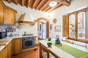 a kitchen with wooden cabinets and a stove top oven at L'arco della Fonte in Gaiole in Chianti