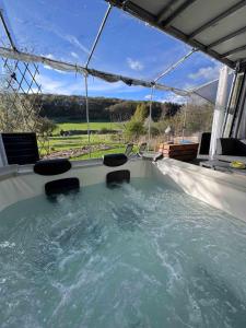 a hot tub with chairs and a view of a field at Eifelsuiten - Private Spa & Family Hideaway - Kerpen Loogh in Kerpen