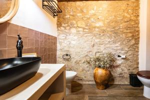 a bathroom with a black sink and a stone wall at Masía Parreta Estancia El Refugio in Villafranca del Cid +25 photos