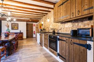 a kitchen with wooden cabinets and a table in a room at Masía Parreta Estancia El Refugio in Villafranca del Cid