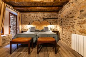 a bedroom with a large bed in a stone wall at Masía Parreta Estancia El Refugio in Villafranca del Cid