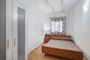 a small bedroom with a bed and a window at Casa Marrero in La Guancha