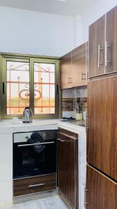 a kitchen with wooden cabinets and a black oven at Welcome Home 102 SaintLouis in Saint-Louis
