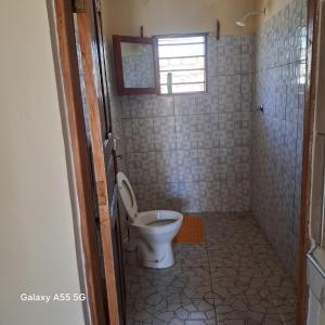 a bathroom with a toilet and a window at Orange apartments 3 in Watamu