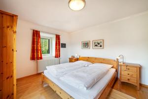 a bedroom with a large bed and a window at Gasserhof Ferienwohnung Edelrot in Caines +30 photos
