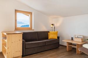 a living room with a couch and a window at Reiterhof Apt Flora in San Genesio Atesino