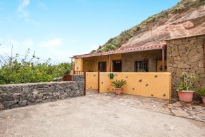 a house with a stone wall next to a mountain at Casa Chinamada in Las Lagunas