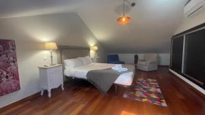 a bedroom with a bed and a chair in a room at Villa Camacho xxvii in Arco da Calheta +12 photos