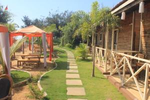a garden with a pathway leading to a house at Boaty's Beach Cottages in Calangute