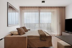ein Schlafzimmer mit einem großen Bett und einem großen Fenster in der Unterkunft Maso Renner in Leifers