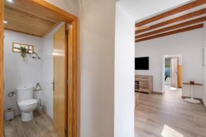 a bathroom with a toilet and a television at Vista Valle in Mogán +21 photos