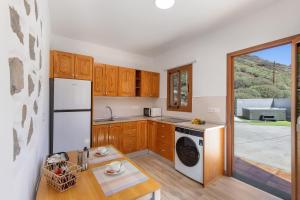a kitchen with a white refrigerator and a dishwasher at Vista Valle in Mogán