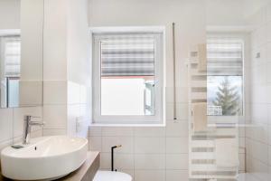 a white bathroom with a sink and a window at Ferienwohnung Tannenblick 6-2 in Oberhof +19 photos