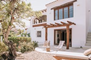 a patio with two chairs and a wooden pergola at The June Boutique in Benissa