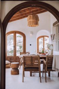 a dining room with a table and two windows at The June Boutique in Benissa