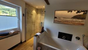 a bathroom with a large tub and a shower at Ferienwohnung Schwarzwald-Traum in Haslach im Kinzigtal +17 photos
