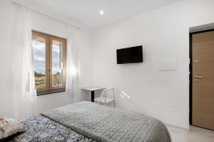a white bedroom with a bed and a window at Silvana's House in Agerola