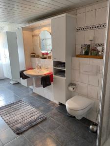 a bathroom with a toilet and a sink at Ferienwohnung an der Berkelquelle in Billerbeck +25 photos