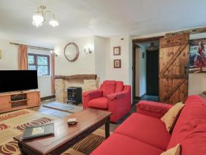 a living room with a red couch and two chairs at Cider House - near Lyme Regis in Axminster