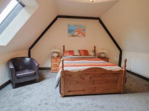 a bedroom with a bed and a chair in a attic at Cider House - near Lyme Regis in Axminster