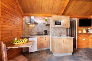 a kitchen with wooden cabinets and a counter with bananas on it at los diablitos 4 in San Juan de la Rambla