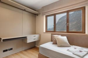 ein kleines Schlafzimmer mit einem Bett und einem Fenster in der Unterkunft Maso Renner in Leifers