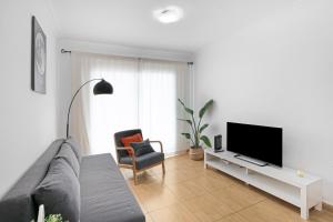 a living room with a couch and a tv at Atico Olia in Los Llanos de Aridane
