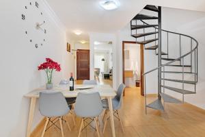 a dining room with a table and a spiral staircase at Atico Olia in Los Llanos de Aridane