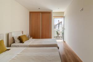 a bedroom with two beds and a large window at Estrelinha do Mar in Apulia in Apúlia +23 photos